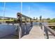 Boat lift mechanism on a wooden dock overlooking the tranquil canal waters, ready for boating at 8774 Mystic Cir, North Port, FL 34287