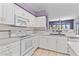 Kitchen boasts white cabinetry and appliances, plus adjacent breakfast bar at 8774 Mystic Cir, North Port, FL 34287