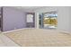Bright living room with carpet flooring and sliding glass doors leading to pool area at 8774 Mystic Cir, North Port, FL 34287