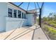 Screened in patio with a concrete floor adjacent to the blue exterior of the home, offering outdoor living at 8774 Mystic Cir, North Port, FL 34287