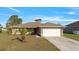 Beautifully landscaped single-story home featuring a two-car garage and a manicured lawn at 121 Long Meadow Ln, Rotonda West, FL 33947