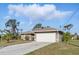 Well-maintained one-story home with an attached two-car garage and a long driveway at 121 Long Meadow Ln, Rotonda West, FL 33947
