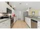 The kitchen features stainless appliances, ample white cabinetry, and a tiled backsplash at 121 Long Meadow Ln, Rotonda West, FL 33947