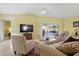 Comfortable living room with neutral decor and views of the screened-in pool area at 121 Long Meadow Ln, Rotonda West, FL 33947