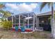 Outdoor pool within screened enclosure, with view into patio and tropical landscaping at 121 Long Meadow Ln, Rotonda West, FL 33947