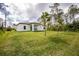 Spacious backyard featuring a covered patio and lush green lawn at 1384 Alpinia Rd, North Port, FL 34288
