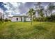 Spacious backyard featuring a covered patio and lush green lawn at 1384 Alpinia Rd, North Port, FL 34288