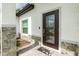 Close up of front door featuring stone accents, a glass paneled door and a welcoming mat at 1384 Alpinia Rd, North Port, FL 34288