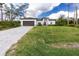 A charming home with a well-manicured lawn and a paved driveway leading to a two-car garage at 1384 Alpinia Rd, North Port, FL 34288