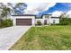 Beautifully landscaped front yard and modern home exterior with a two-car garage and paver driveway at 1384 Alpinia Rd, North Port, FL 34288
