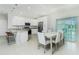Modern kitchen with stainless appliances, granite counters, and a bright dining area with sliding glass doors at 1384 Alpinia Rd, North Port, FL 34288