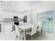 Bright kitchen with stainless appliances, granite counters, and a dining area with sliding glass doors at 1384 Alpinia Rd, North Port, FL 34288