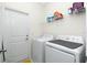 Practical laundry room with washer, dryer, and shelving for storage at 1384 Alpinia Rd, North Port, FL 34288