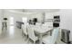 Open-concept living space with a kitchen, dining area, and living room under a tray ceiling at 1384 Alpinia Rd, North Port, FL 34288