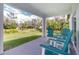 Covered patio featuring four Adirondack chairs and a view of the expansive backyard at 1384 Alpinia Rd, North Port, FL 34288