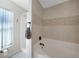 Bright bathroom showcasing a soaking tub, shower, and neutral-toned tile walls at 1406 Woodcrest, North Port, FL 34286