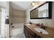 Bathroom featuring a soaking tub, double sinks, dark wood vanity, and soft, neutral tones at 1406 Woodcrest, North Port, FL 34286