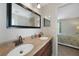 Bathroom with double sinks, dark wood vanity, and large framed mirror offers a modern look at 1406 Woodcrest, North Port, FL 34286