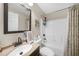 Well-lit bathroom featuring a vanity sink, framed mirror, and a shower/tub combo with decorative curtain at 1406 Woodcrest, North Port, FL 34286
