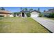Charming single-story home featuring a well-maintained lawn, a two-car garage, and solar panels for energy efficiency at 1406 Woodcrest, North Port, FL 34286