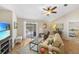 Open living room with tile flooring, a ceiling fan, and sliding glass door leading to the pool area at 1406 Woodcrest, North Port, FL 34286