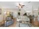Open-concept living room with tile flooring, ceiling fan, and seamless flow to kitchen and dining areas at 1406 Woodcrest, North Port, FL 34286