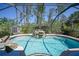 Beautiful in-ground screened pool with rock waterfall feature, mature landscaping and a storage shed at 1406 Woodcrest, North Port, FL 34286