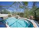 Stunning in-ground screened pool featuring rock waterfall, mature landscaping and plenty of sunshine at 1406 Woodcrest, North Port, FL 34286