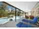 Inviting in-ground screened pool with nearby seating and a rock waterfall feature at 1406 Woodcrest, North Port, FL 34286