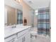 Bathroom with a vanity sink, toilet and tub with shower and blue decorative shower curtain at 14281 Heritage Landing Blvd # 1411, Punta Gorda, FL 33955
