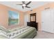 Cozy bedroom featuring a ceiling fan, a dresser and a window view of the lake at 14281 Heritage Landing Blvd # 1411, Punta Gorda, FL 33955