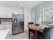 A kitchen with white cabinets and drawers, stainless steel appliances, and a table with chairs near the window at 14281 Heritage Landing Blvd # 1411, Punta Gorda, FL 33955