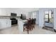 A kitchen with stainless steel appliances, a tile backsplash, white cabinets, and a center island with chairs at 14281 Heritage Landing Blvd # 1411, Punta Gorda, FL 33955
