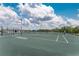 An outdoor tennis court showing a green surface and blue canopy on a sunny day with cloudy skies at 14281 Heritage Landing Blvd # 1411, Punta Gorda, FL 33955