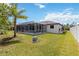 Backyard view featuring a screened pool, well-manicured lawn, and mature landscaping at 1508 Westover St, Port Charlotte, FL 33953