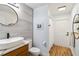 Charming bathroom with wood-look floors, modern vanity, and a stylish round mirror at 1508 Westover St, Port Charlotte, FL 33953