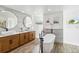 Elegant bathroom with a free-standing tub, double sinks, and wood-look tile flooring at 1508 Westover St, Port Charlotte, FL 33953