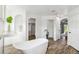 Bright primary bathroom featuring a soaking tub, tile floors, and dual access to the bedroom at 1508 Westover St, Port Charlotte, FL 33953