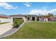 Charming home with a lush lawn and garden, featuring a variety of vibrant plants and flowers at 1508 Westover St, Port Charlotte, FL 33953
