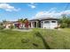 Well-manicured lawn features a decorative garden with a palm tree enhancing curb appeal at 1508 Westover St, Port Charlotte, FL 33953