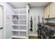 Well-organized laundry area with shelving, modern washer/dryer and wood-look floors at 1508 Westover St, Port Charlotte, FL 33953