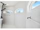Bright shower with white tiles, modern fixtures, and natural light from arched windows at 1508 Westover St, Port Charlotte, FL 33953
