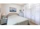 Calm bedroom featuring a bed with striped bedding, white dresser, and closet doors at 1515 Forrest Nelson Blvd # L204, Port Charlotte, FL 33952