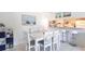 Bright dining room with white table and chairs adjacent to a kitchen with bar seating at 1515 Forrest Nelson Blvd # L204, Port Charlotte, FL 33952