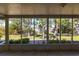 View from screened back porch overlooks the spacious, lush backyard with mature trees and brick-lined patio at 1516 Saint Clair Rd, Englewood, FL 34223