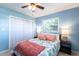 Bright blue bedroom features a large window, ceiling fan, and closet at 1516 Saint Clair Rd, Englewood, FL 34223