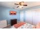 Cozy bedroom with a ceiling fan, TV, and blue accent wall that enhances the room's appeal at 1516 Saint Clair Rd, Englewood, FL 34223