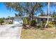 Charming single-story home featuring a lush front yard and a large driveway leading to an attached garage at 1516 Saint Clair Rd, Englewood, FL 34223