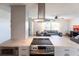 Modern kitchen with stainless steel appliances, sleek range hood, and open view to the living area at 1516 Saint Clair Rd, Englewood, FL 34223