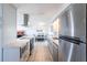 Modern kitchen with stainless steel appliances, including range hood and refrigerator at 1516 Saint Clair Rd, Englewood, FL 34223